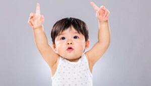 A baby girl reaching out with her fingers