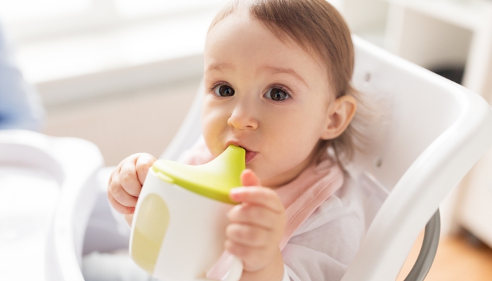 https://www.wonderbaby.org/wp-content/uploads/2022/07/Little-baby-drinking-from-spout-cup-sitting-in-highchair-at-home.jpg