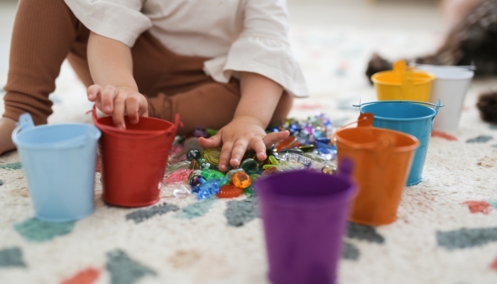 https://www.wonderbaby.org/wp-content/uploads/2023/11/Toddler-girl-plays-with-beads-and-multicolored-buckets.jpg