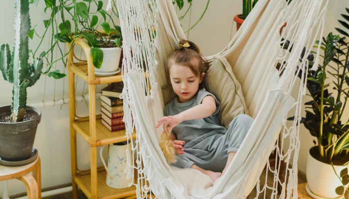 Little child playing in hammock at home