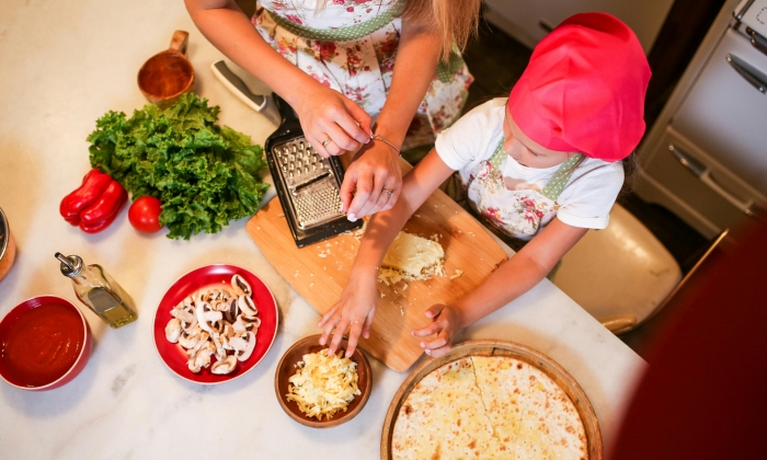 Mother and Daughter Preparing Pizza on Kitchen Counter Table
