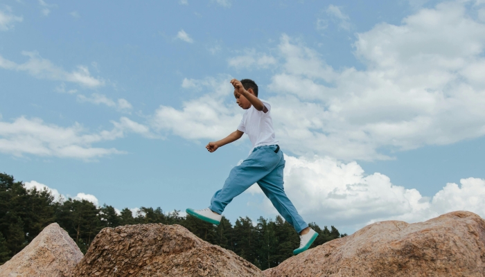 A Boy Jumping over the Rocks