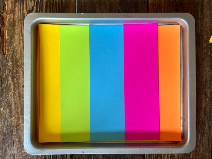 Color Surprise Salt Tray for Handwriting Practice layering the colored paper