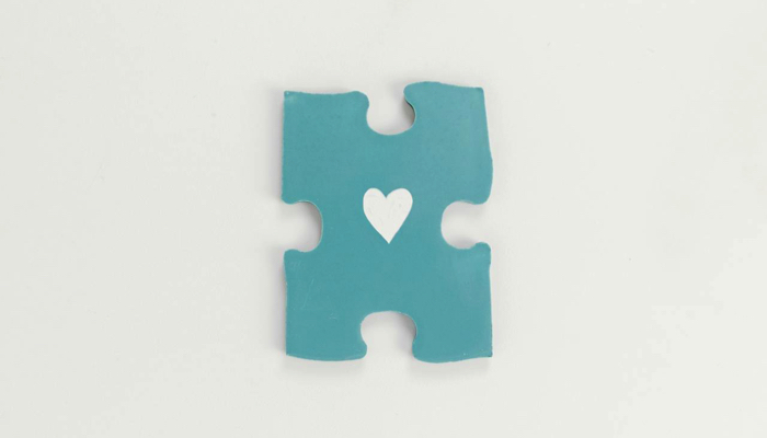 Blue puzzle piece with a heart.