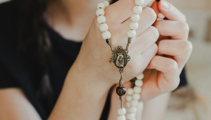 Woman praying the rosary.