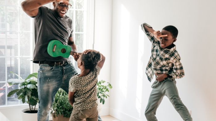 Father and children practicing dynamic and static balance through freeze dancing activity