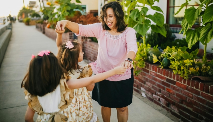 Mother Dancing with Her Daughters on the Street