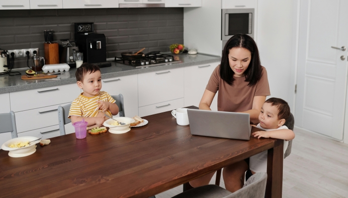 Mother Sitting with her Children in a Kitchen