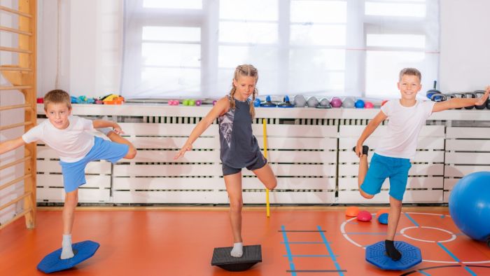 Three children maintain balance in a single-leg stance