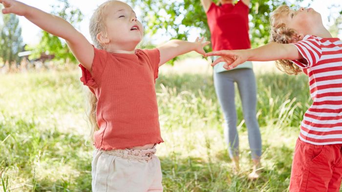 Woman teaching emotional regulation to her children through taking deep breaths