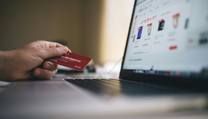 Black and Gray Laptop Computer With Turned-on Screen Beside Person Holding Red Smart Card in Selective-focus Photography