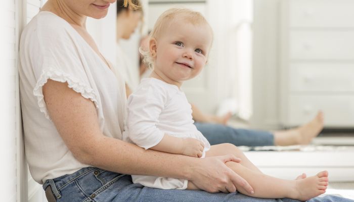 Adorable baby girl with mother at home