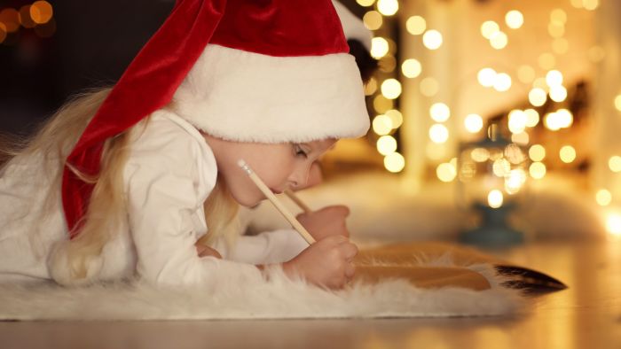 Girl writing a letter to Santa on christmas eve.