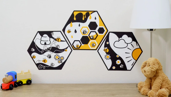 Bright and bold busy bee wall art in a baby's nursery.