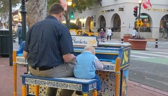 Skylar and Peter playing piano together.